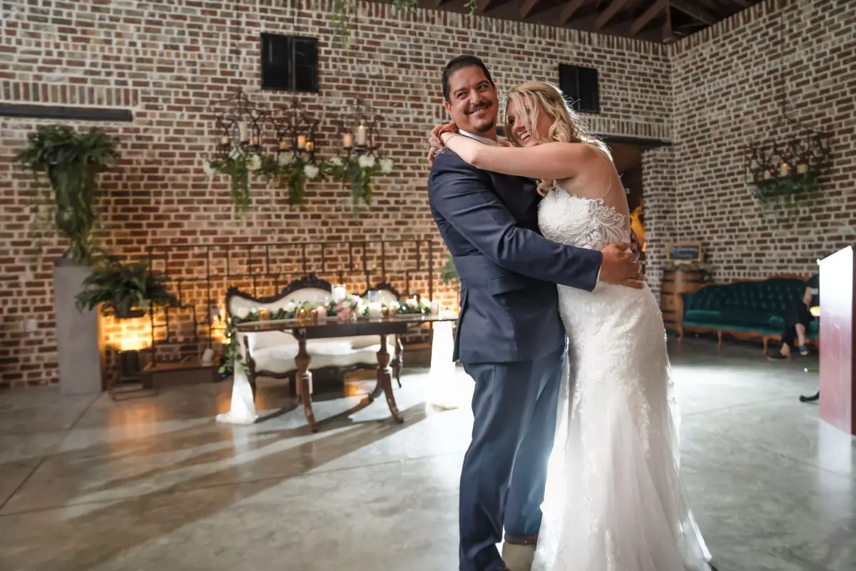 Couple embracing by the greenery wall in the Live Oak Plantation reception